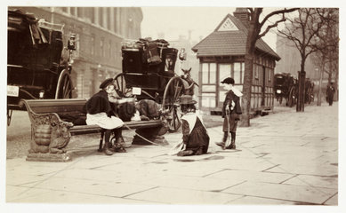 Children playing by a Hansom Cab rank  c 1900.