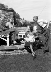 Family sitting in a garden  c 1948.