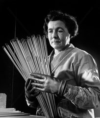 A female employee with rods of carbon electrodes used by arc welders  1961.