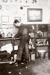 C S Rolls in overalls working in his garage  c 1900.