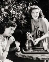 Two young women enjoying a summer drink  1945-1955.