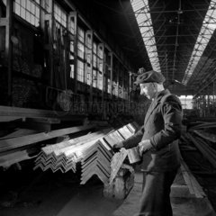 A fitter marks off girders at Whessoe Ltd  1950. Long view of Section shop .