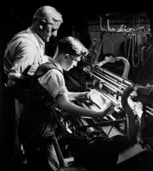 A master trains a young apprentice in machine knitting  Lyle and Scott  Hawick.