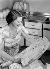 Woman unpacking a box of laundry  1950.