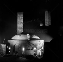 Worker fires a kiln of tiles at night  Wheatley Quarries  1952.