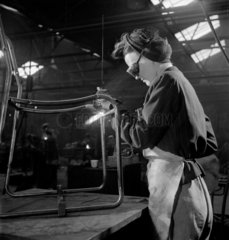 Female welder working on PEL steel and canvas chair  1948.