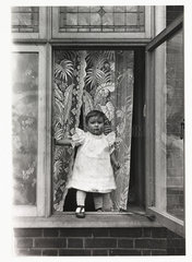 Child at a window  c 1910.