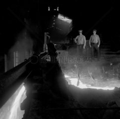 Molten steel flows past two furnace workers  Consett Iron Company  1957.