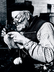 Elderly man knitting as part of the war effort during WWII  31 October 1939.