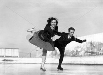 Couple skating on an open-air ice rink  c 1930s.