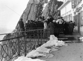 People gathered by a chalet on a mountain p