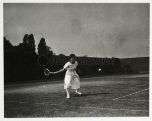 Woman playing tennis  c 1925.