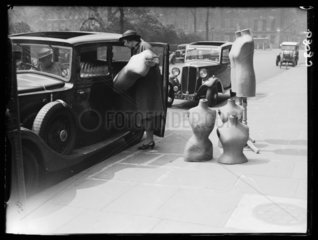 Unloading dressmaking dummies from a car  1932.