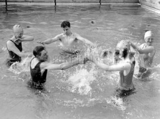 People splashing in a pool  Chiswick open-air baths  London  13 May 1931.