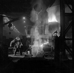 A spectacular image of a foundry worker tending molten iron  Burton  1953.