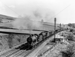 Two steam locomotives double-heading a freight train  c 1958.