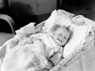 Baby in a cot  c 1949