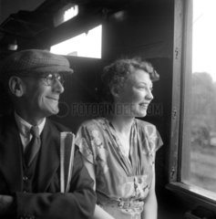 Elderly man and young woman looking out of carriage window  1950.