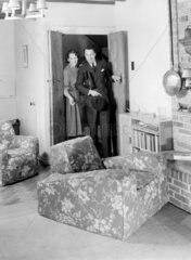 Couple entering a room  c 1950.