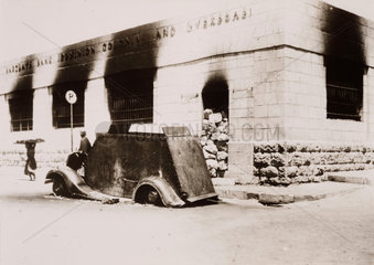 Burnt-out armoured car outside Barclays Bank  Hebron  1938.