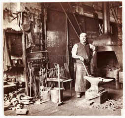 Blacksmith in a foundry  c 1905.