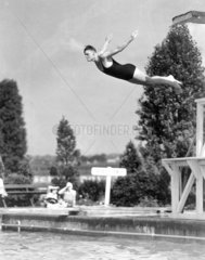 Young man diving from a high board into an