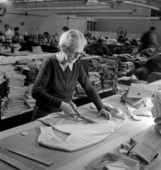 Elderly woman cuts woolen material by hand at Lyle and Scotts  1951.