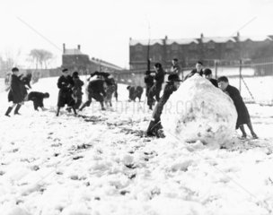 Children pushing a huge ball of snow  North London  27 January 1935.