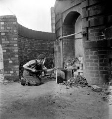 Worker stokes kiln  the nIght shift  Wheatley Quarries  1952.