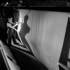 Worker winds a section of carpet from reel  Kossett Carpets  Brighouse 1956.