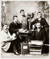 Group of photographers and assistants with equipment  19th century.