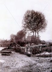 Adults and children on a wooden bridge over