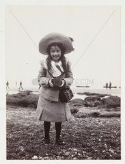 Kodak Brownie girl on beach holding a Kodak Brownie camera  c 1900.