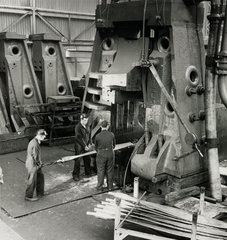 Foundry men inserting blank aluminium blade under heavy hammer  1961.