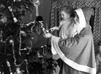 Father Christmas and a young child  c 1930.