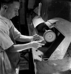 Worker finishing a telephone case  GEC  1953.