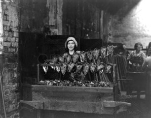Kipper girl displaying smoked kippers  24 September 1931.