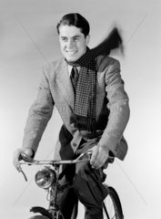 Man riding a bicycle  c 1950.