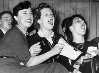 Three girls shout with joy while listening to Frankie Laine  1953.