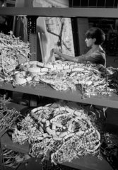 A female worker assembles computer parts in the cable forming section  1967.