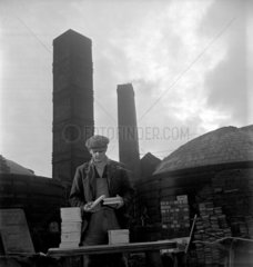 Quarry worker sorts floor tiles outside kilns  Wheatley Quarries  1952.