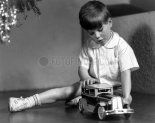 Boy playing with a toy car at Christmas  c