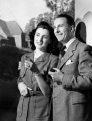 Smiling couple outside a house  1950.