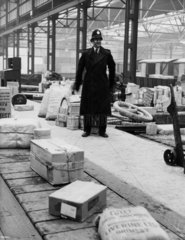 British Transport policeman in a goods depot.