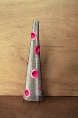 A silver coloured cone with pink indentatio
