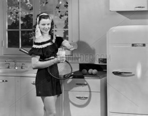 Tennis player in a kitchen  c 1950.
