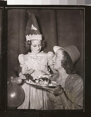 Vera Lynn offering nine-year-old Hester Goldstein a piece of cake  1949.
