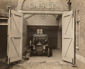 Motor car in a garage  c 1910s.