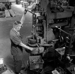 A fitter at his press makes ball bearings  Skefco plant  1957.