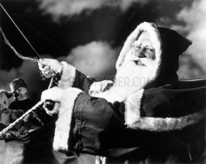 Father Christmas riding in his sleigh  c 1940s.